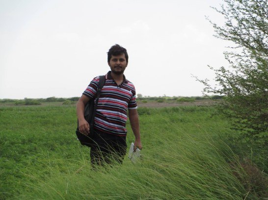 Standing in a green field with a backpack, 2013