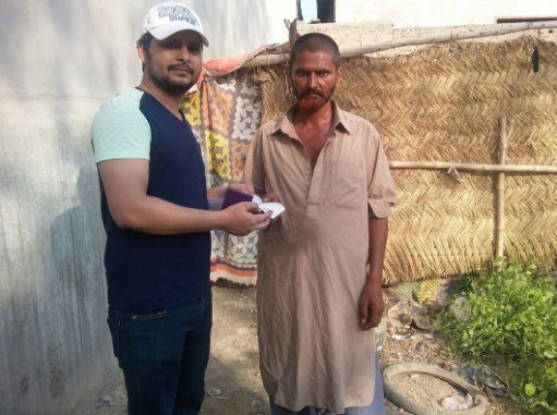 Mueez Khan meeting a community member outside a reed hut during a SHADE field visit